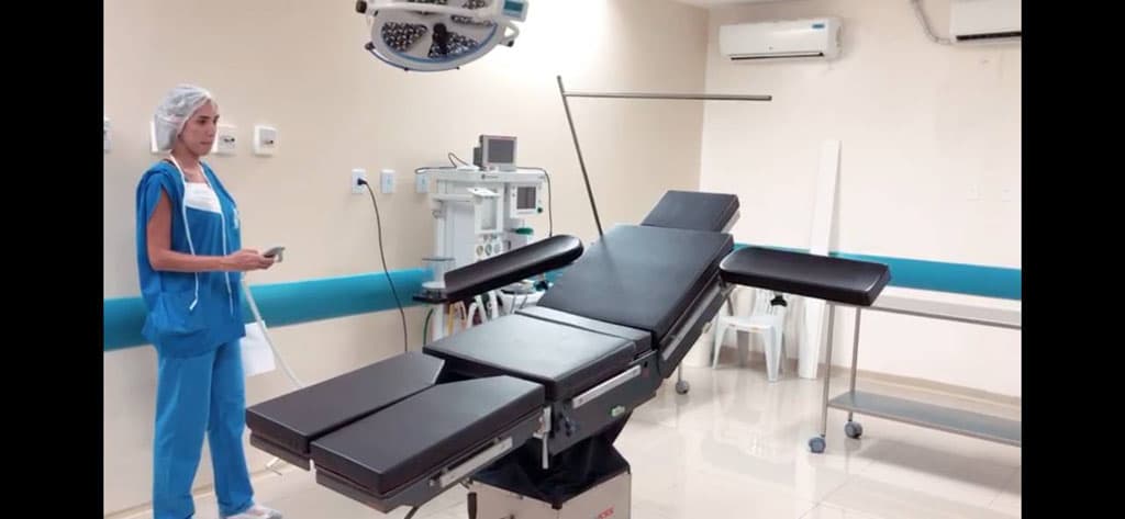Sala cirúrgica com mesa, foco cirúrgico e equipamentos de anestesia